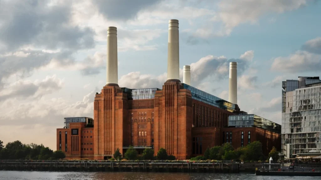 Exterior view of Battersea Power Station with its four iconic chimneys against a cloudy sky