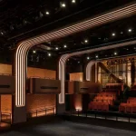 Wide interior shot of Apple Music Hall looking toward the stage under warm lighting
