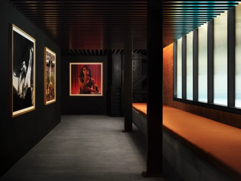 Corridor or backstage area with framed photographs and warm lighting