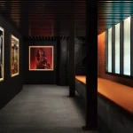 Corridor or backstage area with framed photographs and warm lighting