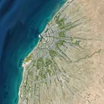 High-altitude aerial of Benghazi showing the dense urban grid meeting the coastline