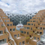 Can architecture really solve social problems? This critical essay examines Bjarke Ingels’ optimistic design philosophy, public architecture, sustainability, accessibility, and the limits of architectural agency.