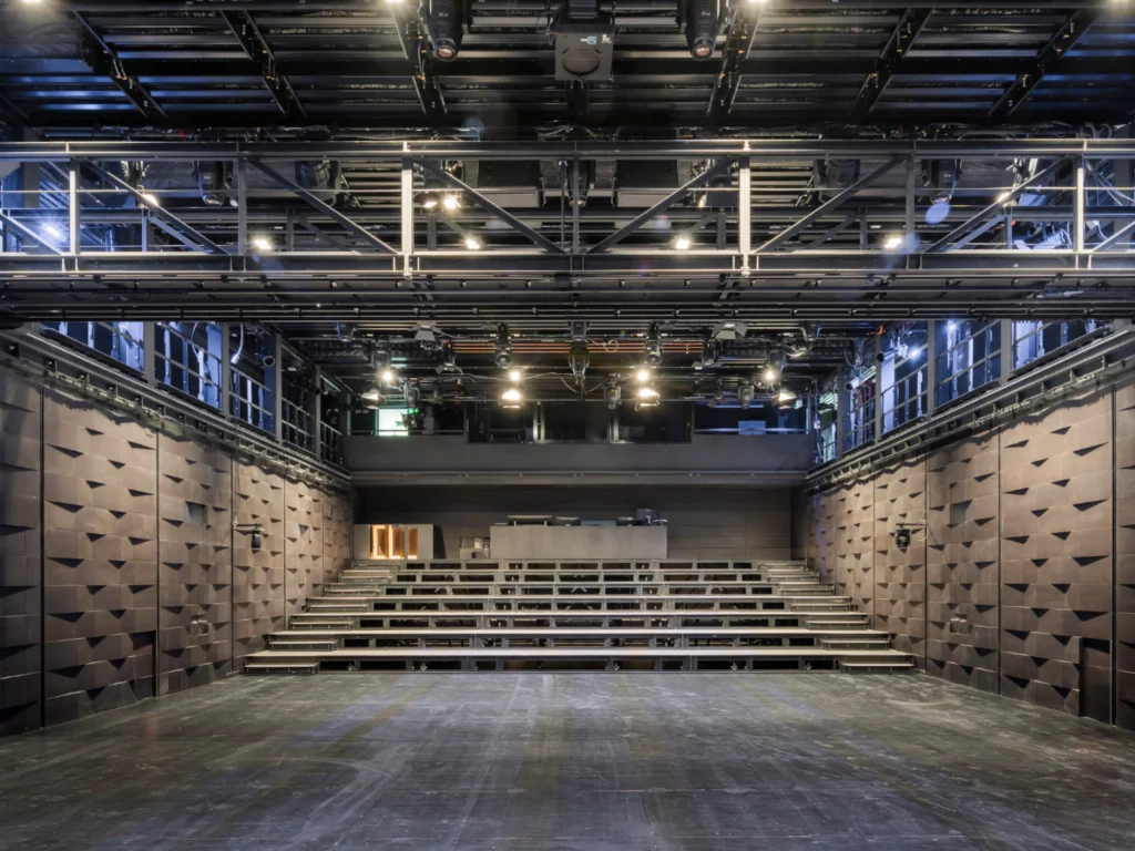 Empty black-box style theatre space with flexible seating and technical grid