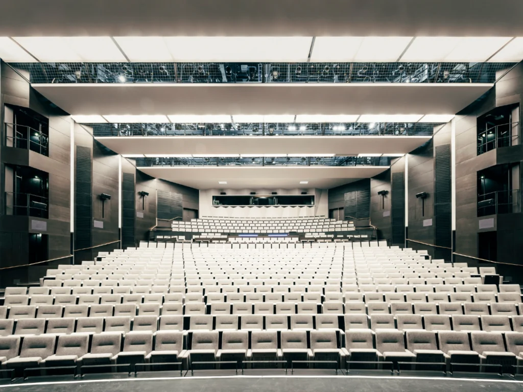 Wide view of a bright, modern auditorium with white seating and clean lines