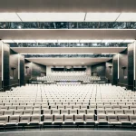 Wide view of a bright, modern auditorium with white seating and clean lines