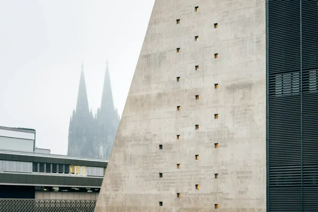 Exterior detail of the concrete façade with Cologne Cathedral visible in the background