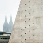 Exterior detail of the concrete façade with Cologne Cathedral visible in the background