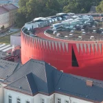 Aerial view of the elliptical red arena and surrounding buildings