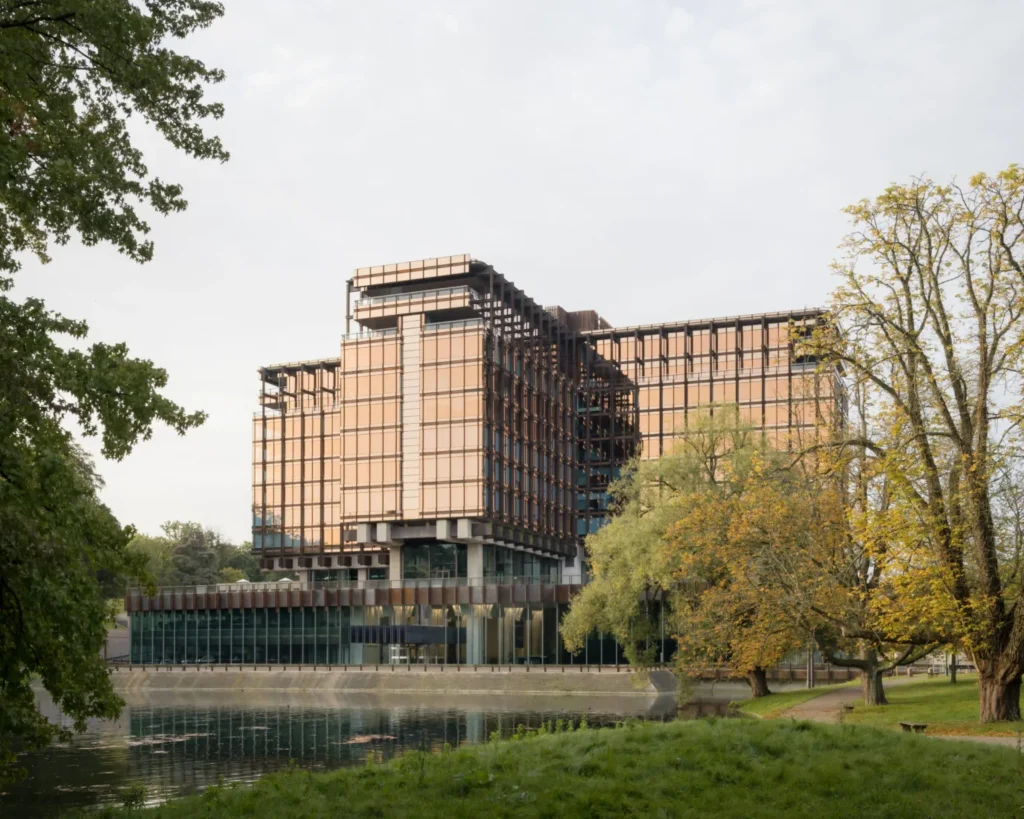 Caruso St John Exterior view of the cross-shaped Royale Belge building surrounded by trees in Brussels