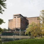 Caruso St John Exterior view of the cross-shaped Royale Belge building surrounded by trees in Brussels