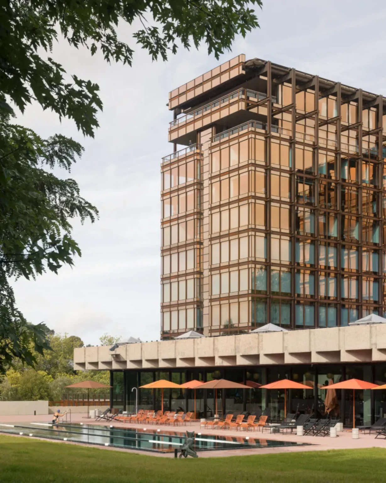 Closer exterior of Royale Belge showing the Modernist tower among mature trees