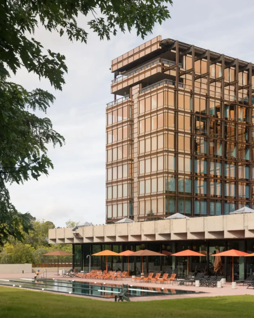 Closer exterior of Royale Belge showing the Modernist tower among mature trees