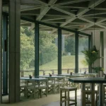 Glass-walled interior area overlooking greenery at Royale Belge