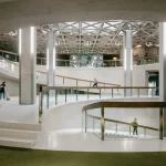 Multi-level interior view with staircase, columns and natural light