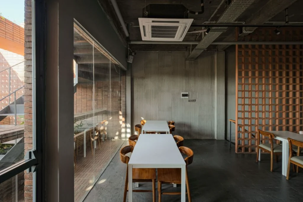 Interior working space with long table, brick screens and natural light