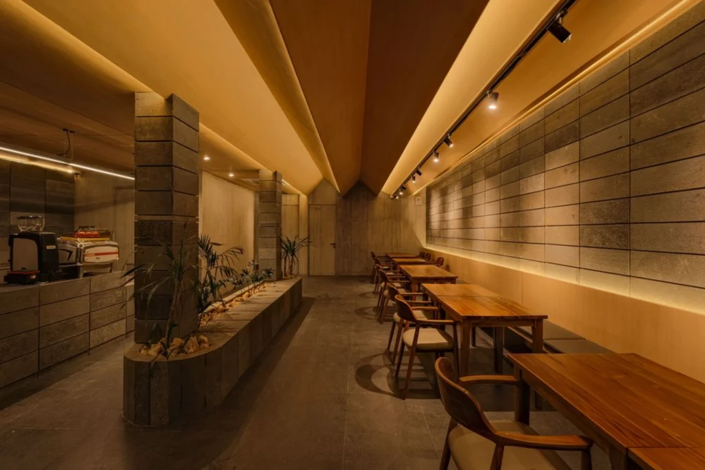 Ground-floor coffee bar and seating area with warm lighting and stone surfaces