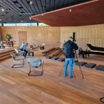Open interior of the Ammann Pavilion with wooden floor, piano and people seated