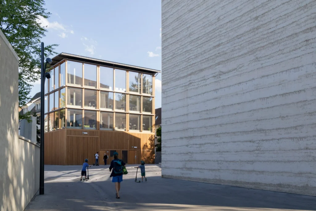 Exterior view of a new Zumthor building with visitors approaching the entrance