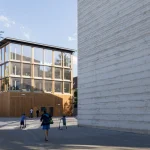 Exterior view of a new Zumthor building with visitors approaching the entrance