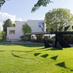 Wider park view showing the new buildings set within the lawn and mature trees