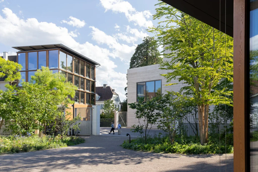Close exterior view of the Wyss Museum’s rammed-concrete façade with visitors near the entrance