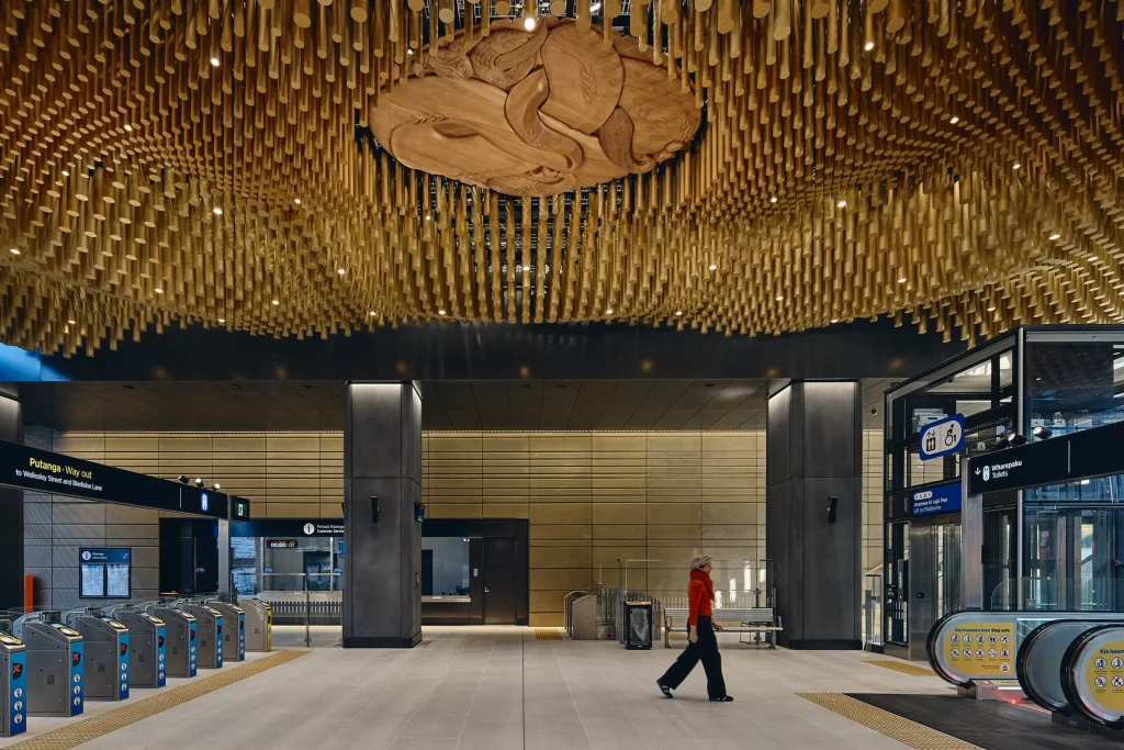 Ceiling installation of golden anodised aluminium rods at Te Waihorotiu Station