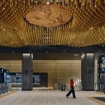 Ceiling installation of golden anodised aluminium rods at Te Waihorotiu Station
