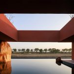 Long horizontal hotel complex stretching across open agricultural fields at golden hour