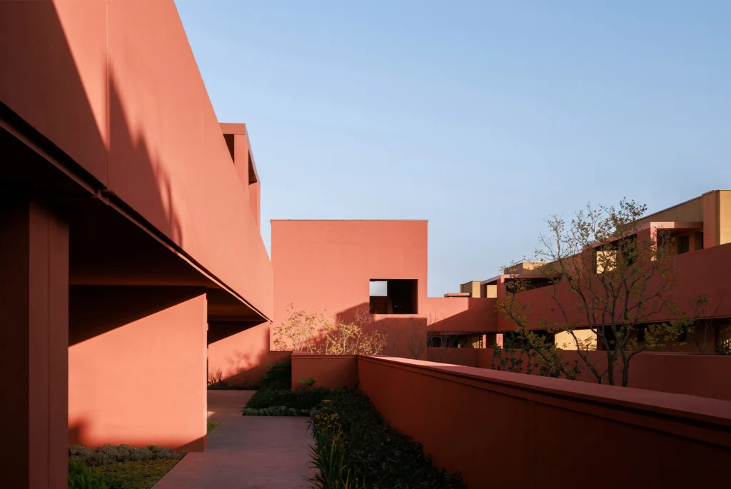Long horizontal hotel complex stretching across open agricultural fields at golden hour