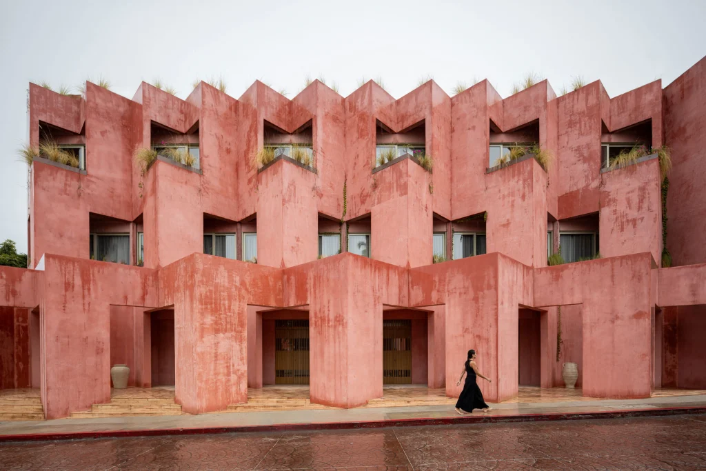 Exterior street view of Laiva Plaza Hotel showing the stepped coral-red stucco facade in San José del Cabo