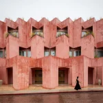 Exterior street view of Laiva Plaza Hotel showing the stepped coral-red stucco facade in San José del Cabo