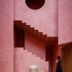 Three-quarter view of Laiva Plaza Hotel’s layered pink facade with multiple balconies and terraces