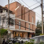 Side elevation of the brick hotel with street activity and neighbouring buildings