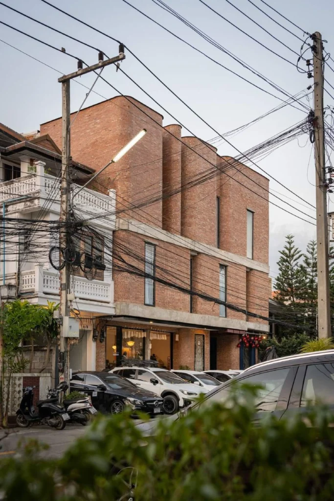 Side elevation of the brick hotel with street activity and neighbouring buildings