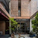 Ground-floor entrance and courtyard edge with bicycle and potted plants