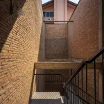 Brick stairwell with black metal railing and open light well