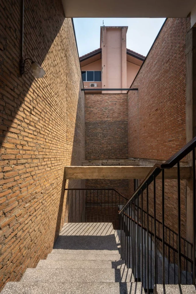 Brick stairwell with black metal railing and open light well