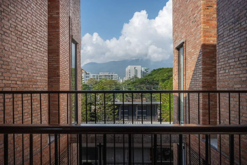 Upper-level brick opening framing a view of distant green hills