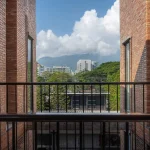 Upper-level brick opening framing a view of distant green hills