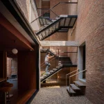 Multi-level interior view of brick walls, stairs and open voids