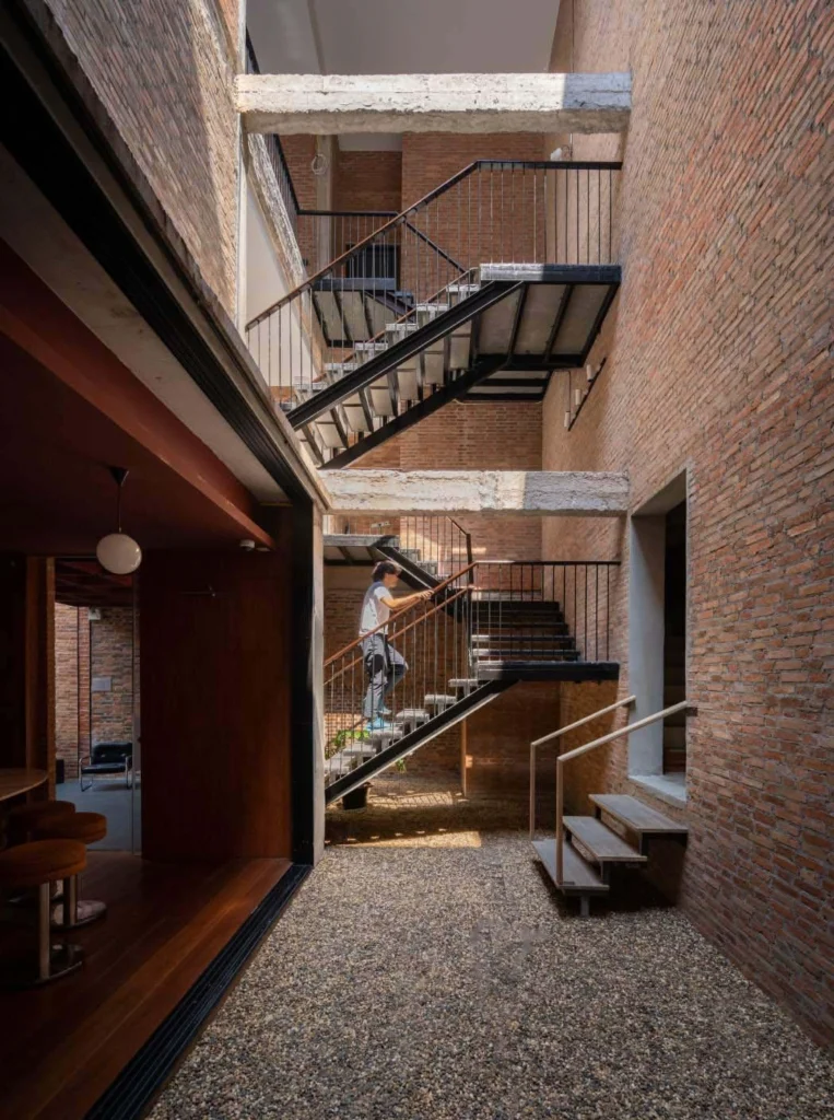 Multi-level interior view of brick walls, stairs and open voids
