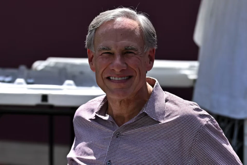 Texas Governor Greg Abbott standing outdoors near a stadium