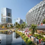 Close view of the stadium’s diamond lattice facade beside a canal lined with people carrying Vietnamese flags