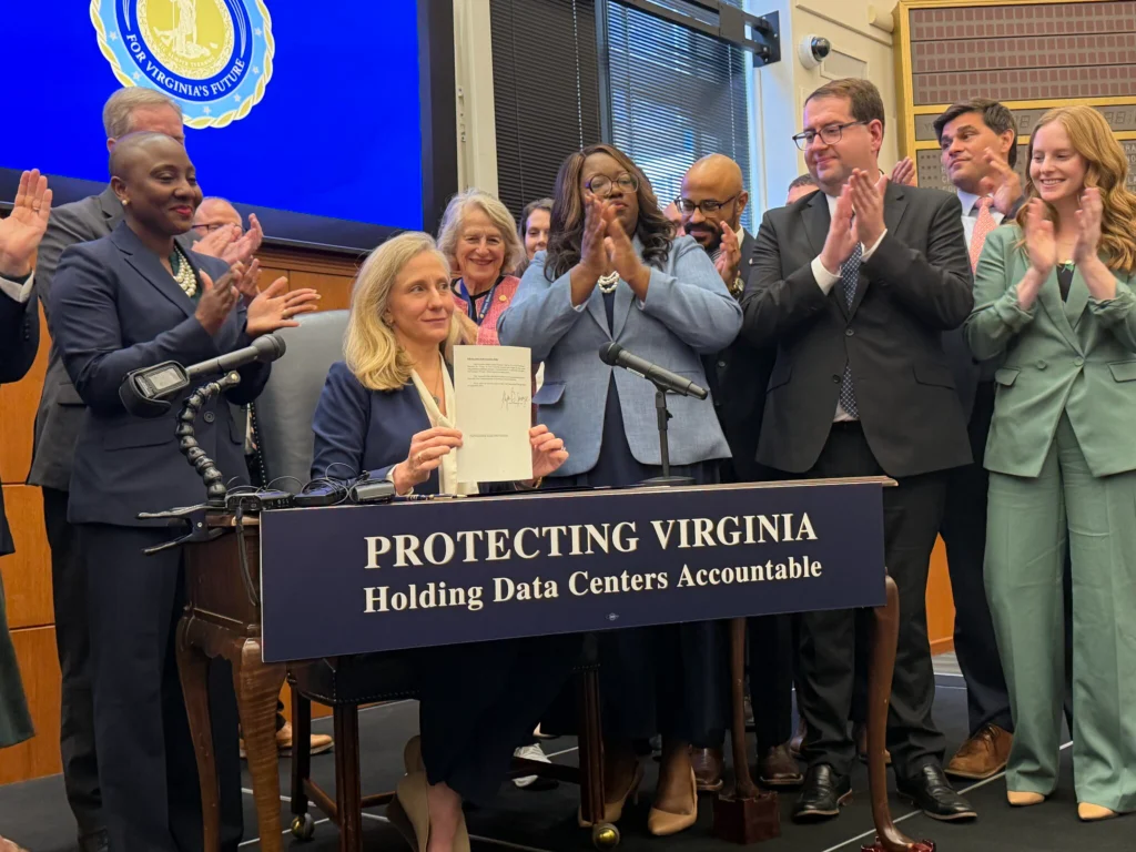Virginia Governor Abigail Spanberger signing Executive Order 22 at a formal desk in Richmond