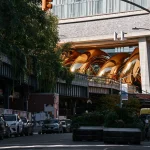 auruBOROS golden coils rising beside High Line walkers and city buildings