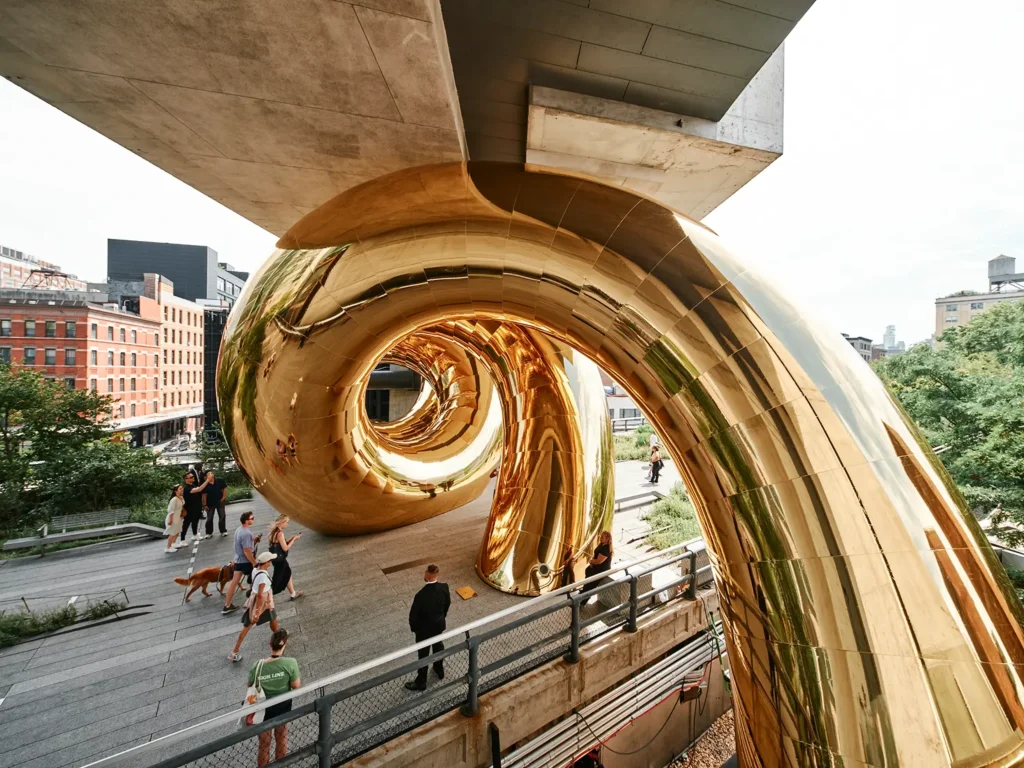 Close-up of the curved golden membrane reflecting trees and sky