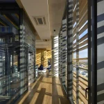Open-plan interior workspace with long free spans and full-height glazing