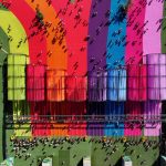 Aerial view of rainbow-coloured pathways and modular fabric structures with crowds walking between them