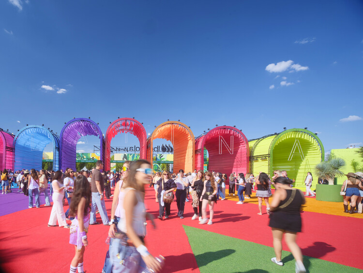 BIG Turns Madrid into Macondo Park for Shakira’s Residency_Daytime view of arched fabric pavilions spelling letters across a red plaza filled with visitors