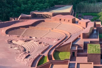 Aerial view of the reddish-brown amphitheater seating curving into the green hillside